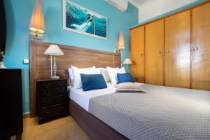 a bedroom with a large bed with blue walls at Irini Apartment I in Kalyves