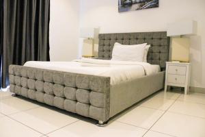 a large bed with a large headboard in a bedroom at Luxurious inn at Embassy Gardens in Accra