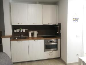 a kitchen with white cabinets and a sink at Costa Adeje Apartments in Adeje
