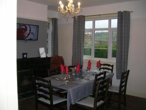 a dining room with a table with red napkins at Bevan House with Hot Tub in Mid-Wales in Hundred House