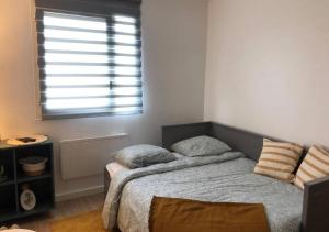 una camera da letto con un letto con due cuscini e una finestra di L'Évasion - Studio - Vue mer a Calais
