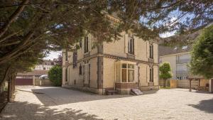 una grande casa di mattoni con una panchina di fronte di La Clé des Sens - Univers Envoûtant et Sensuel a Troyes