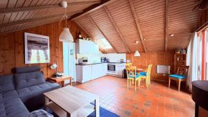ein Wohnzimmer mit Couch und Tisch und eine Küche in der Unterkunft Ferienhaus "Sören" in Glücksburg