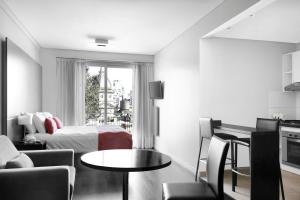 Habitación de hotel con cama, mesa y sillas en CH Recoleta Suites en Buenos Aires