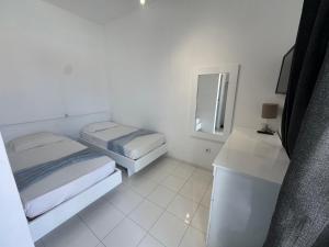 una camera da letto bianca con due letti e uno specchio di Académico do Sal a Espargos