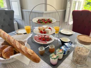 a table with a breakfast of bread and fruit and orange juice at Château Planquery - Viking Heritage, Pet Friendly in Planquery +27 photos