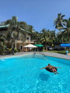 a woman laying in the water in a swimming pool at Bregman Residance in Plaridel