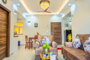 a living room with two couches and a table at Alaya Stays 2 BHK with Balcony & Lift - Veera Marina in Goa
