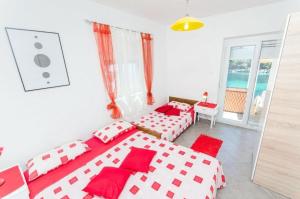 a bedroom with two beds and a view of the ocean at House Vatromir in Bogomolje