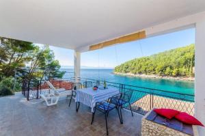 a table and chairs on a balcony with a view of the ocean at House Vatromir in Bogomolje