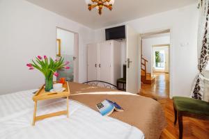 une chambre avec un lit avec un vase de fleurs sur une table dans l'établissement House Bozica with sauna and pool, à Tribalj