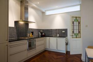 a kitchen with white cabinets and a sink and a window at Marnix360apartments Classic in Amsterdam