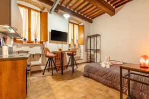 a room with a bed and a table and a kitchen at La Casina Mag Pienza in Pienza