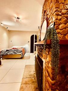 a bedroom with a bed and a stone wall at Pousada Casinha Amarela - Campos do Jordão in Campos do Jordão