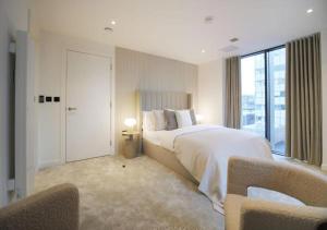 a bedroom with a large bed and a large window at Elysium by The Heim Residences in Manchester