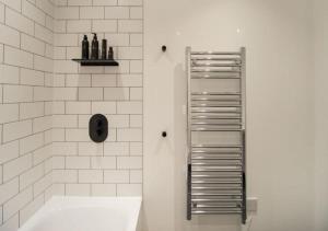 a bathroom with a white tub and a towel rack at Elysium by The Heim Residences in Manchester +34 photos