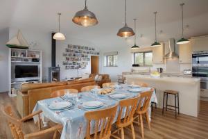 a dining room and kitchen with a table and chairs at Sloopside Main House in the heart of Bantham with sea views in Bantham