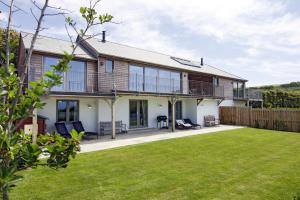an exterior view of a house with a yard at Sloopside Main House in the heart of Bantham with sea views in Bantham
