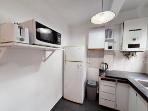 a kitchen with a white refrigerator and a microwave at Oslo- Urbano y Residencial in La Plata