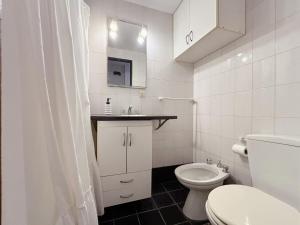a white bathroom with a toilet and a sink at Oslo- Urbano y Residencial in La Plata +10 photos