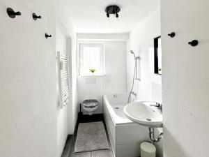 a white bathroom with a toilet and a sink at Cozy & warm Apartment in Ennepetal in Ennepetal