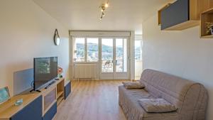 una sala de estar con un sofá y un televisor en Le Belvédère - WIFI Fibre - Parking gratuit, en Gap