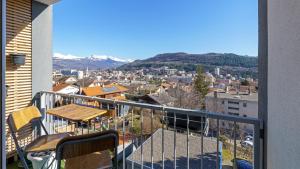 Un balcón con una mesa y vista a una ciudad. en Le Belvédère - WIFI Fibre - Parking gratuit, en Gap