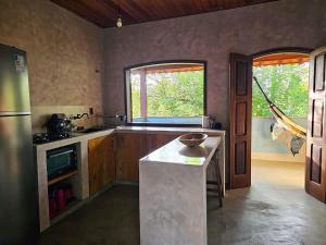 a kitchen with a counter and a window in it at Casa de Lux in Ilha de Boipeba