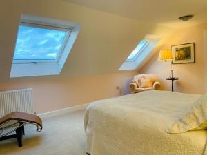 a bedroom with a bed and two windows at Magog View in Sawston