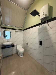 a bathroom with a toilet and a sink and a mirror at Kaliningrat Cottage 2 in Pronojiwo