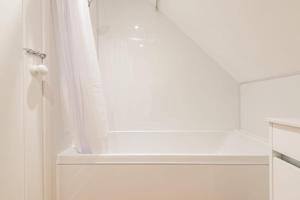 a bathroom with a shower with a white shower curtain at The Old Barn in Sandwich +23 photos