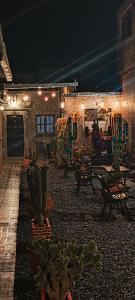 a patio with a bunch of cactuses and tables and chairs at Tilcara Hostal Niña Coya in Tilcara