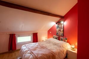 a red bedroom with a bed and a window at Valmy in Brantôme