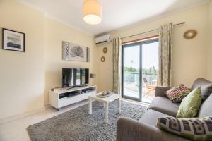 a living room with a couch and a tv at Vista Das Ondas 308 By RS in Olhos de Água