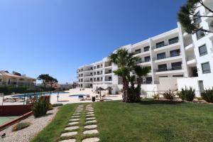 a large apartment building with a lawn and palm trees at Vista Das Ondas 308 By RS in Olhos de Água
