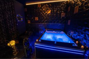 a room with a tub in a blue room at Appartement Romance et chic in Bevons
