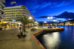 a building next to a body of water at night at RHODESIA guest house in Chalkida
