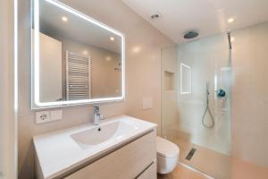 a white bathroom with a sink and a shower at Windsong in Port de Pollensa +19 photos