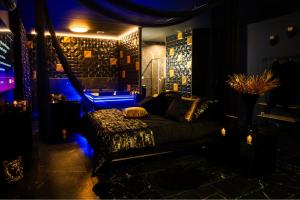 a dark room with a bed and a blue light at Appartement Romance et chic in Bevons +20 photos