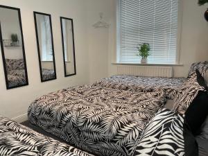 a bed in a room with a comforter at House in Central Bournemouth in Bournemouth +17 photos