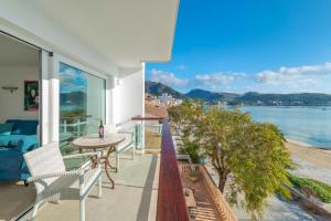 a balcony with a table and chairs and a view of the water at Windsong in Port de Pollensa