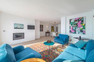 a living room with a blue couch and blue chairs at Windsong in Port de Pollensa