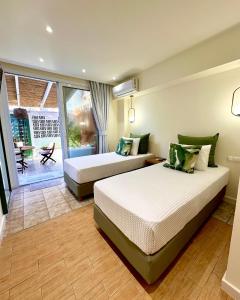 a hotel room with two beds and a balcony at Αλσύλλιο - Alsillio studio apartments in Ierissos