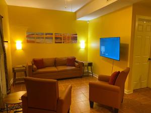 a living room with a couch and a flat screen tv at Five Elements Lodge B&B with Outdoor Spa in Fernwood