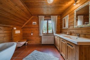 bagno con vasca, lavabo e servizi igienici di Dachstein Chalet - Mountain view a Bad Goisern