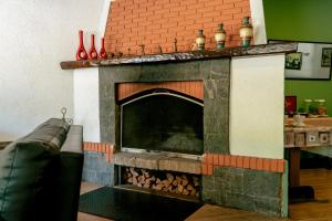 a living room with a fireplace with vases on top at Hotel Geneve - 2km do Capivari in Campos do Jordão