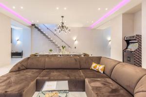 a living room with a brown couch and a table at Bliss Triplex - Hyper Centre - Sauna - BBQ - Jacuzzi - LRACANNES in Cannes +45 photos