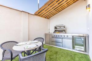 un patio con tavolo, sedie e stufa di Bliss Triplex - Hyper Centre - Sauna - BBQ - Jacuzzi - LRACANNES a Cannes