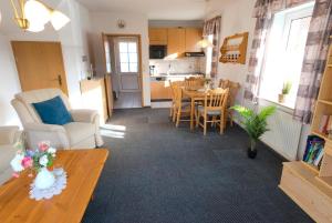 a living room with a table and a kitchen at Ferienhaus Gruber in Norddeich