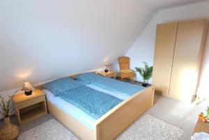a bedroom with a bed with blue sheets and a nightstand at Ferienhaus Gruber in Norddeich